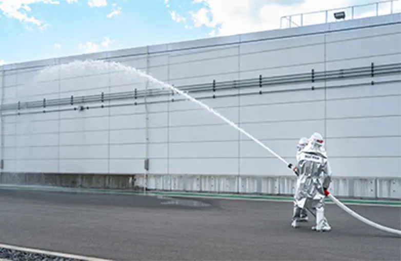2人組でホースを持ち放水訓練を行う様子