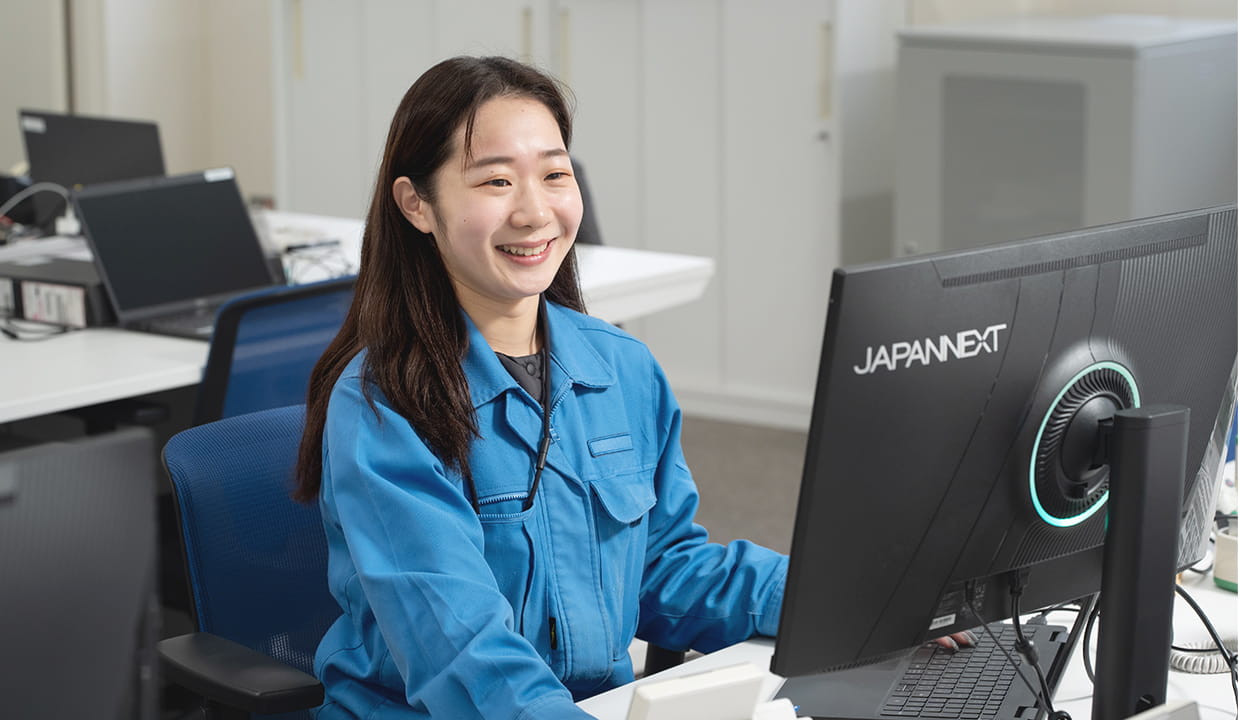 大きなモニターのパソコンで作業をする女性
