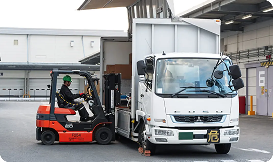 フォークリフトで荷物をトラックの荷台に乗せている様子