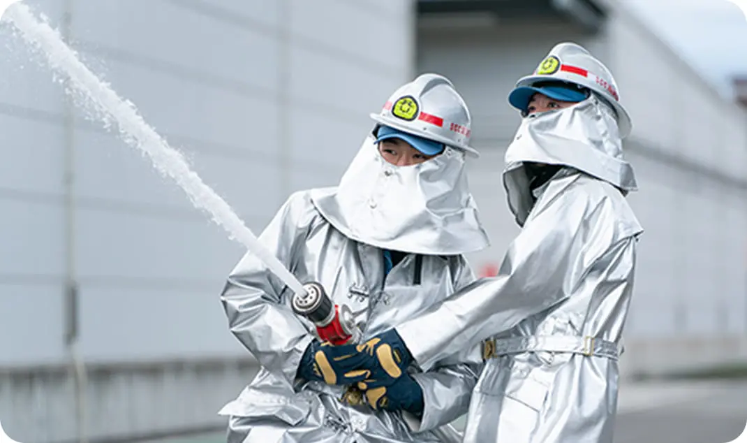 2人組でホースを持ち放水訓練を行う様子