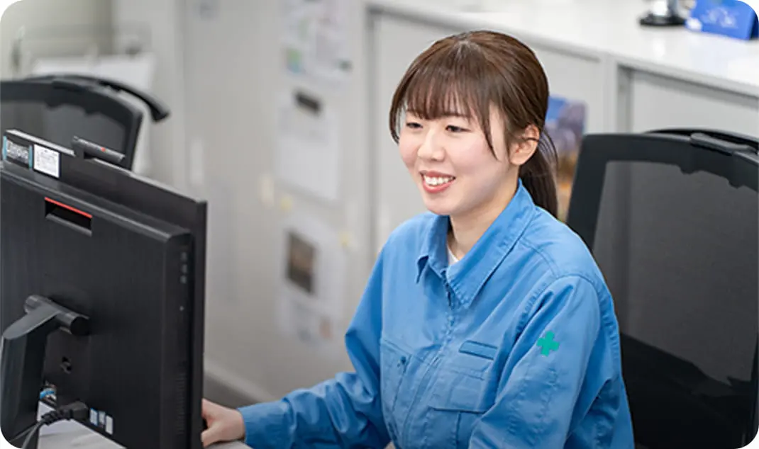 パソコンで作業をする青い制服を着た女性