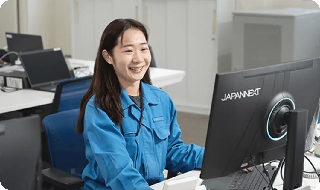 パソコンで作業をする青い制服を着た拠点コントロールスタッフの女性