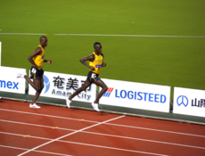 LOGISTEED看板前を通過するロノ選手(右)、リチャード選手(左)